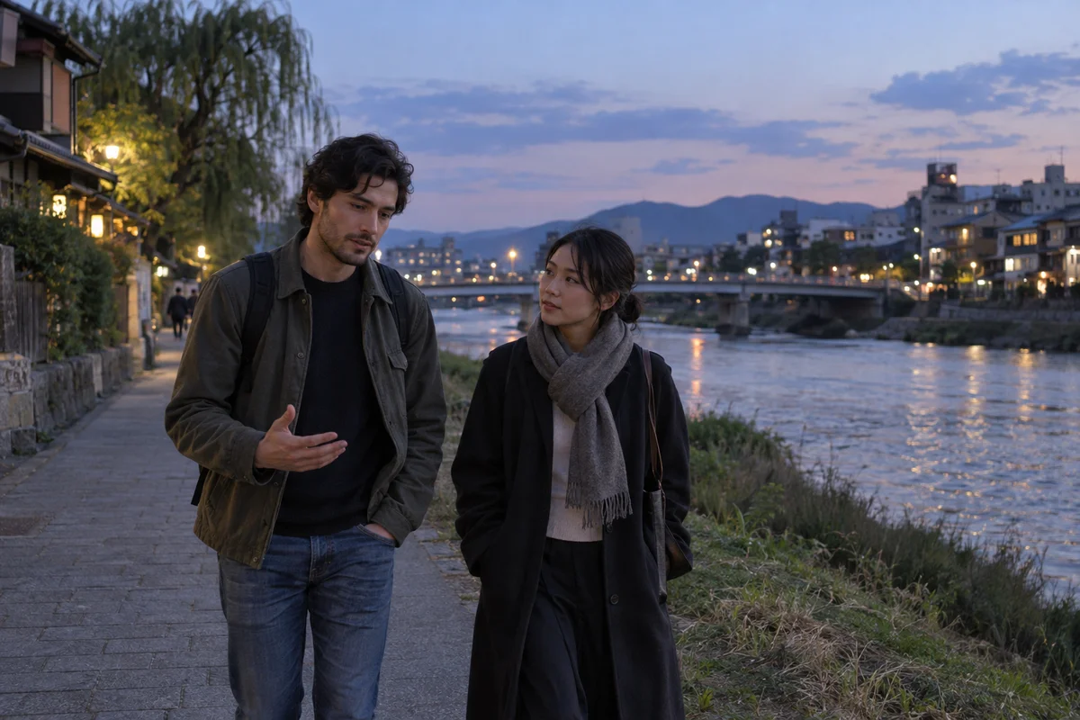 Two friends walking side by side along a quiet riverside path in Japan at dusk, one listening closely while the other talks